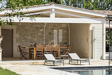 A patio with a table and chairs next to a pool