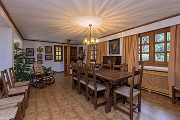 A dining room with a wooden table and chairs