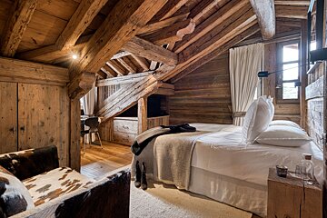 A bedroom with a bed and a candle on a nightstand