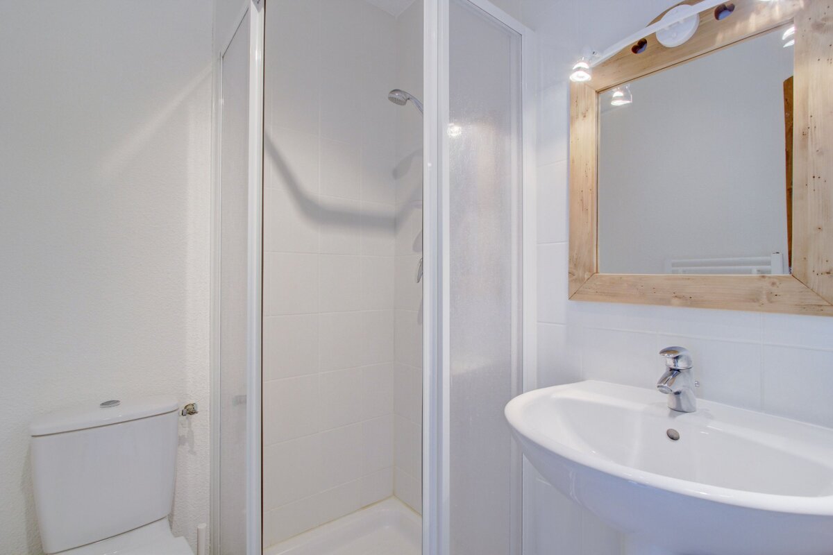 A bathroom with a toilet a sink and a mirror
