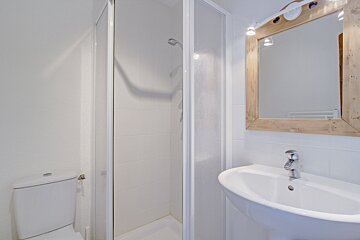 A bathroom with a toilet a sink and a mirror