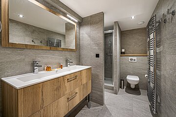 A bathroom with two sinks and a toilet