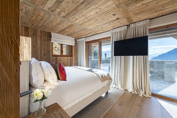 A bedroom with a large bed and a flat screen tv