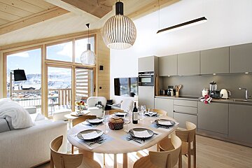 A dining room table with a bottle of wine on it
