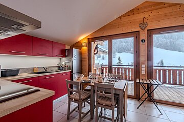 A kitchen with red cabinets and a large window