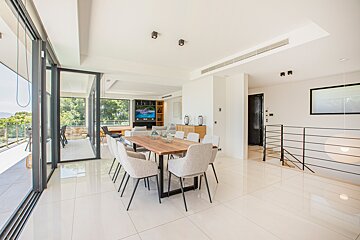A dining room with a table and chairs and a television