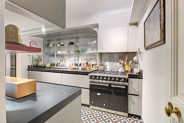 A kitchen with a black stove and white cabinets