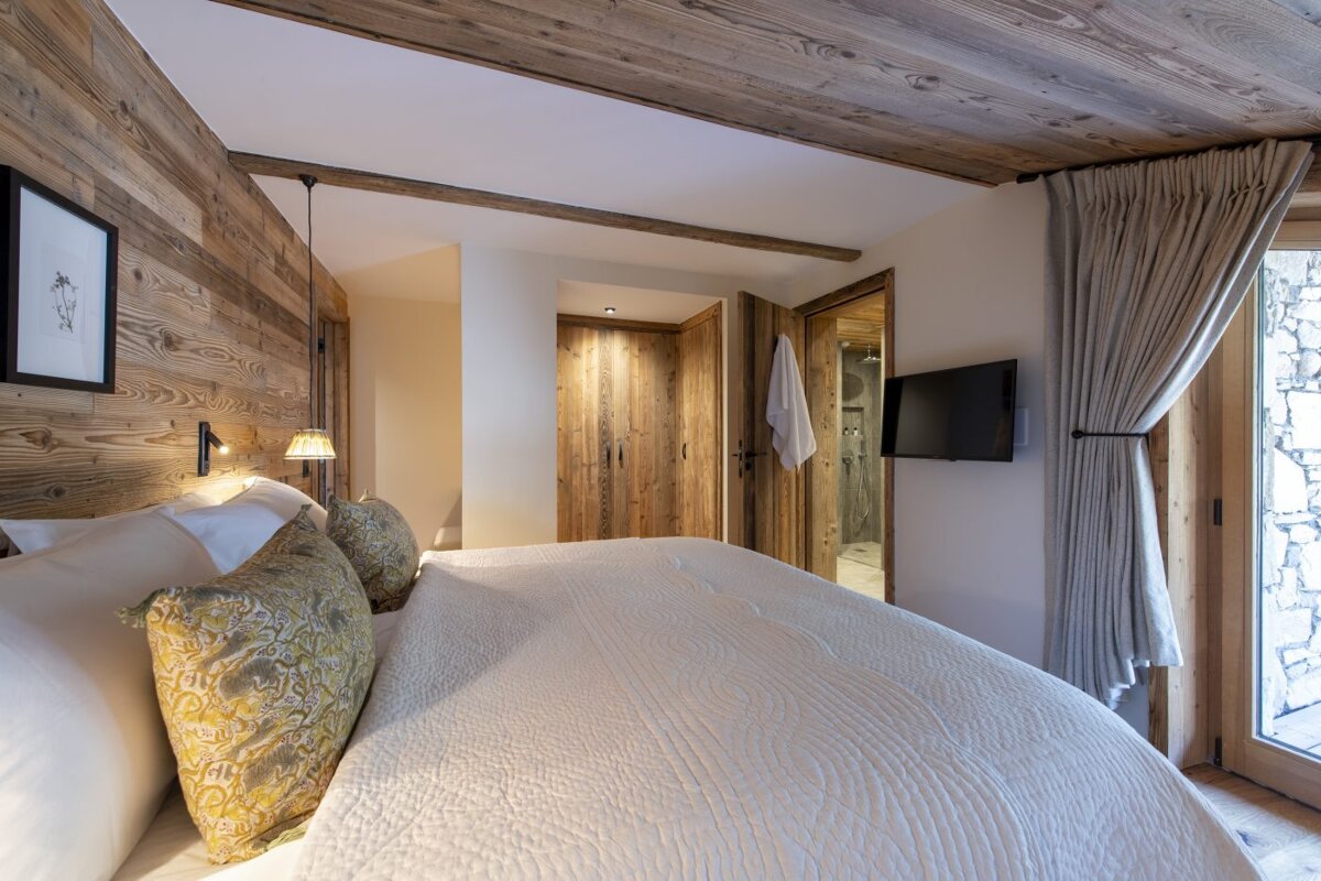 A bedroom with a large bed and a flat screen tv