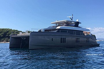 A large gray and white yacht is floating in the ocean