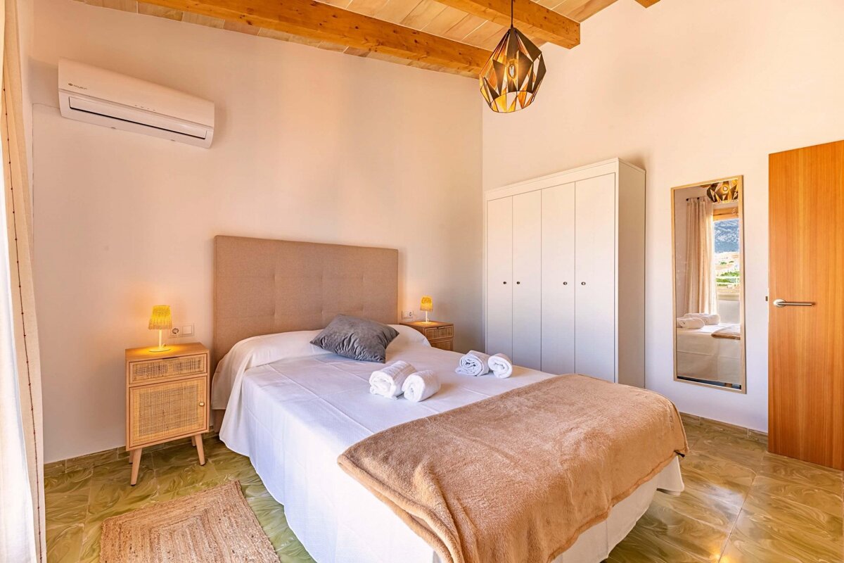 A bedroom with a king size bed and a mirror