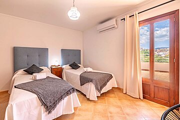 A bedroom with two beds and a sliding glass door
