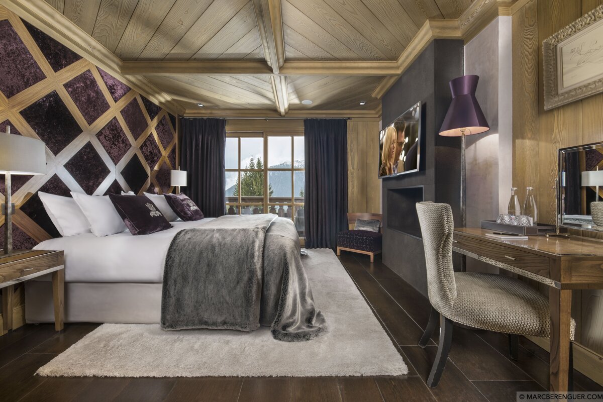 A bedroom with a large bed and a desk