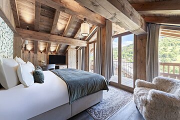 A bedroom with a large bed and lots of windows