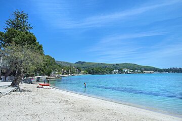 A beach with a red kayak in the water