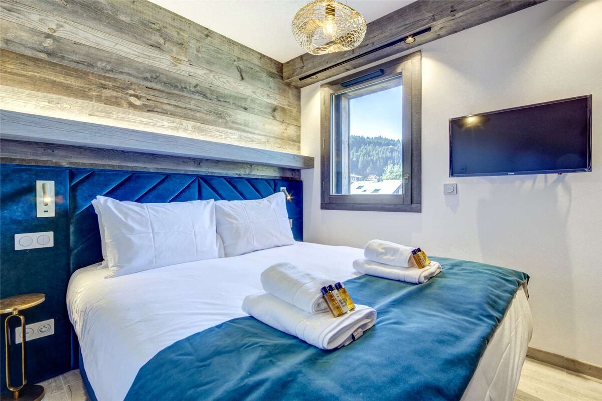 A hotel room with a large bed and a flat screen tv