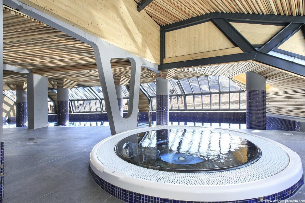 A swimming pool with a jacuzzi in the middle of it