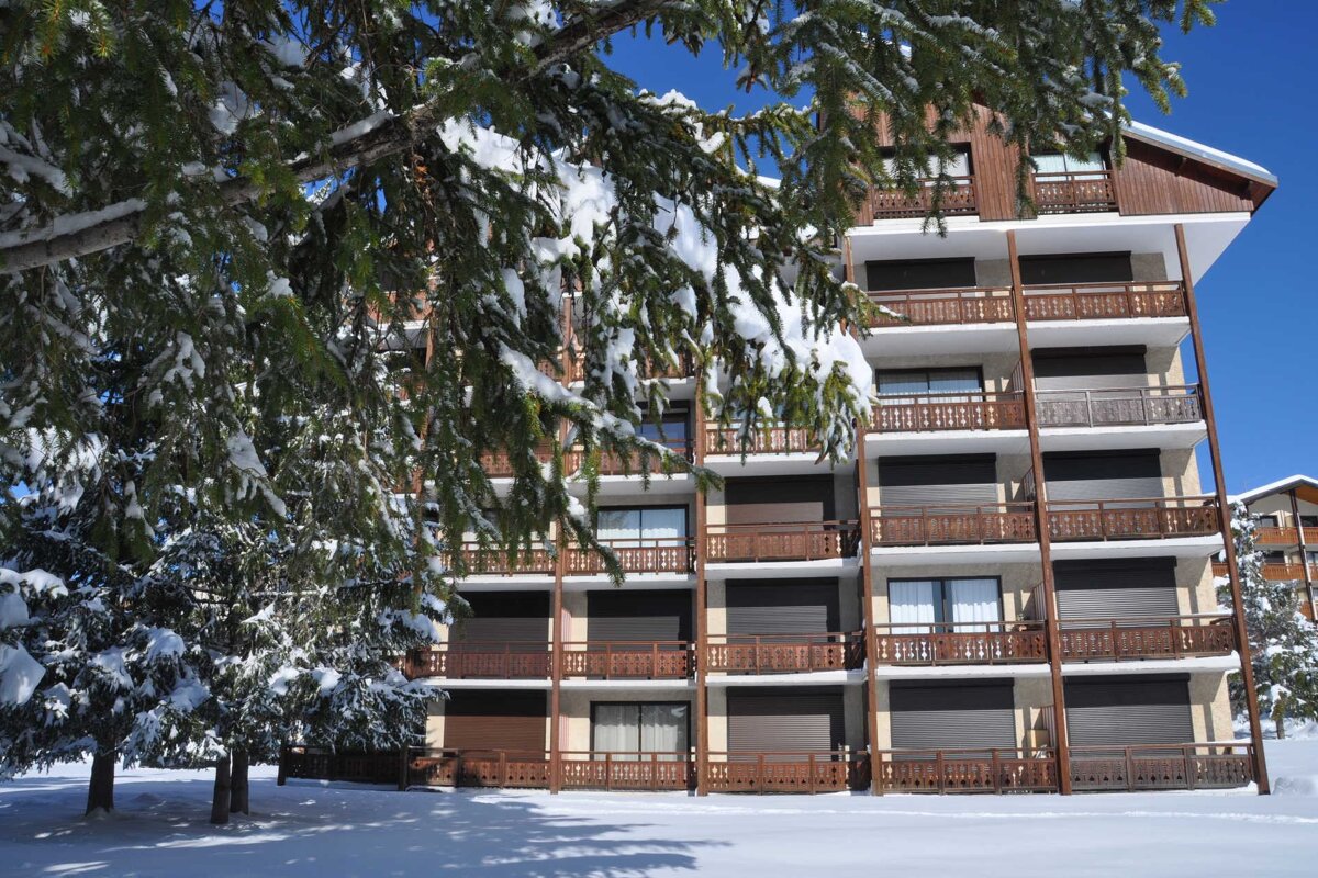 A building with a lot of balconies is covered in snow