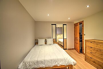 A small bedroom with a bed and a dresser