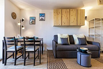 A living room with a couch and a table and chairs