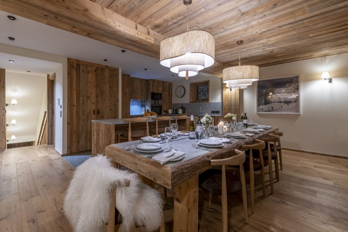 A dining room with a long wooden table and chairs