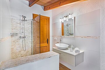 A bathroom with a sink and a walk in shower