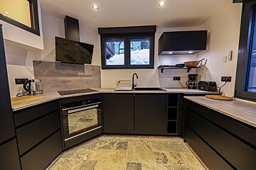 A kitchen with black cabinets and a stove top oven