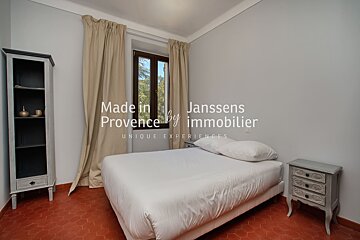A bedroom with a bed and a bookcase that says made in provence by immobilier