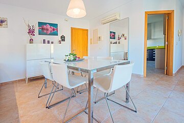 A dining room with a table and chairs and a mirror