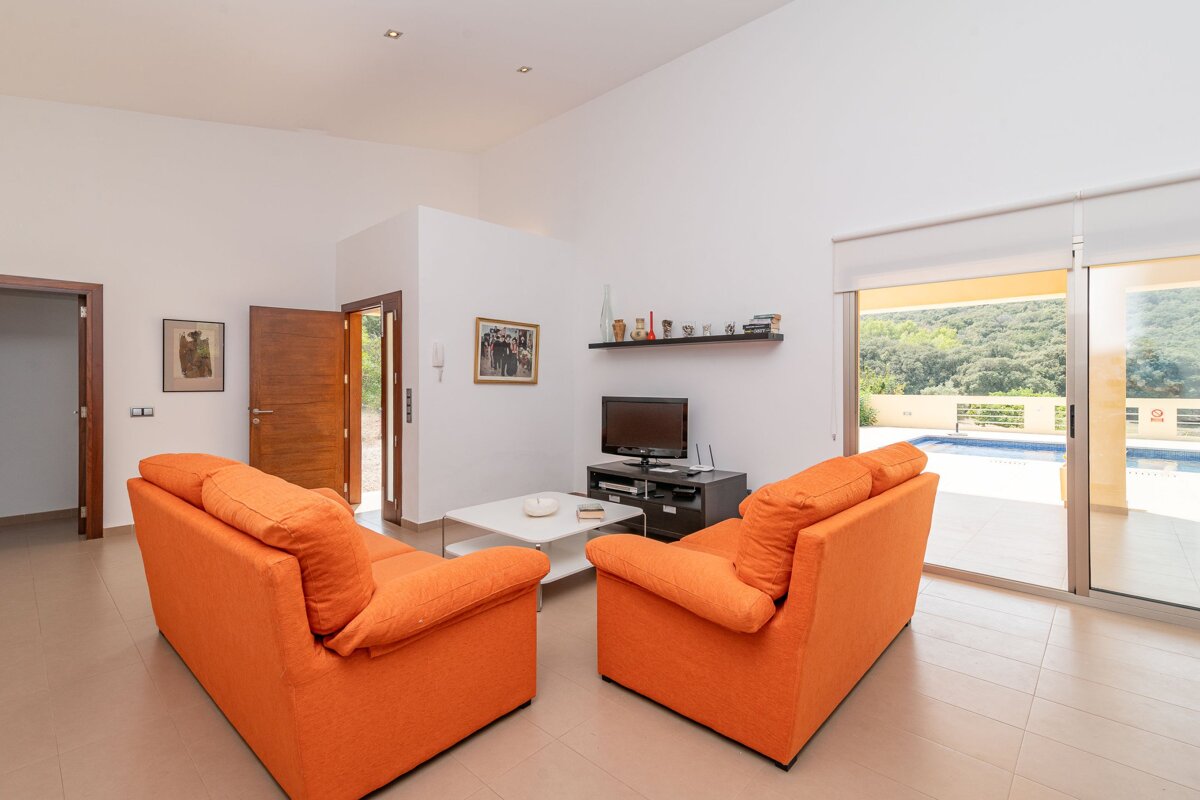 A living room with two orange couches and a flat screen tv