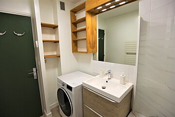 A bathroom with a washer and dryer and a sink