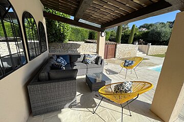 A patio area with a couch and two chairs