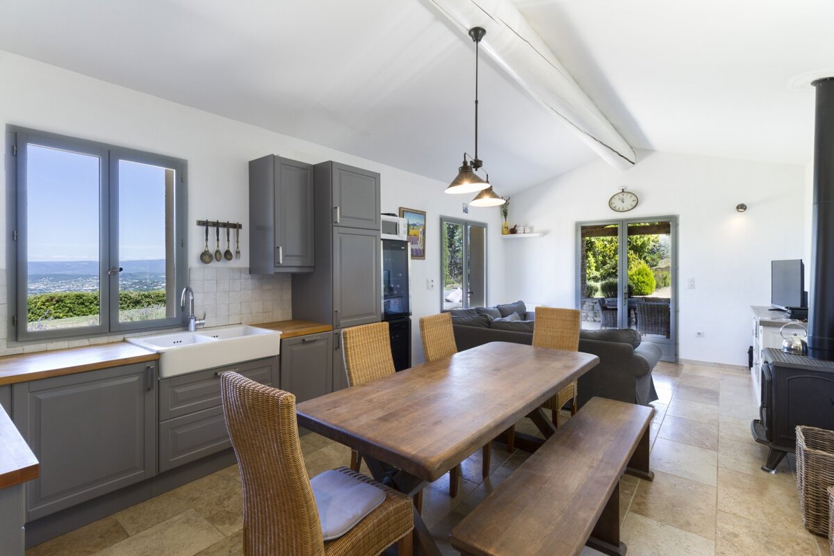 A kitchen with a table and chairs and a clock on the wall