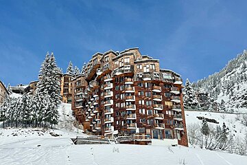 A building with a lot of windows is covered in snow
