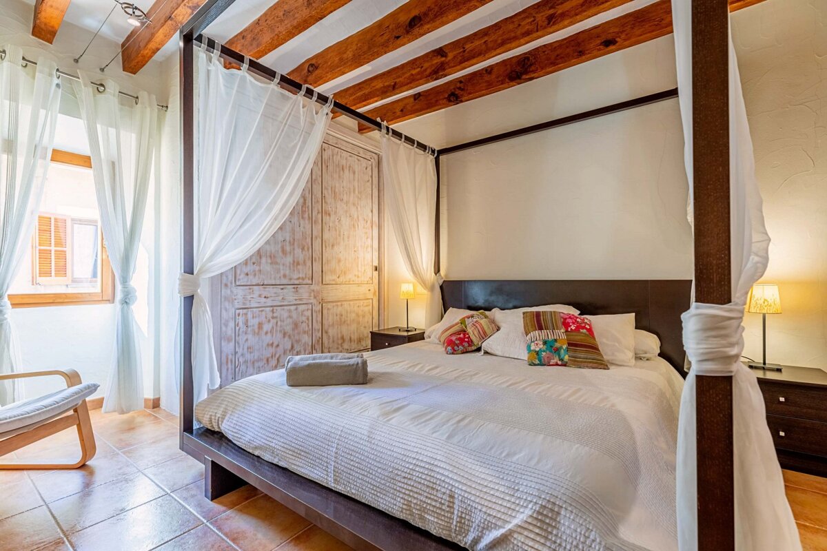 A bedroom with a canopy bed and a chair