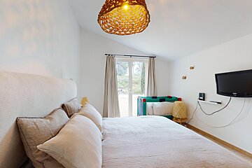 A bedroom with a large bed and a flat screen tv