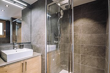 A bathroom with a sink and a walk in shower