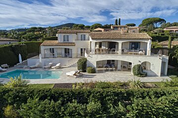 A large white house with a swimming pool in front of it