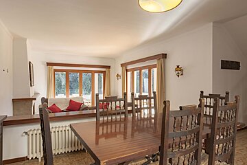 A dining room with a wooden table and chairs