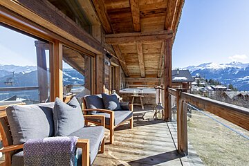 A wooden balcony with a view of the mountains