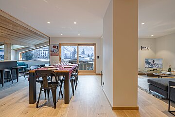 A dining room with a table and chairs and a coca cola poster on the wall