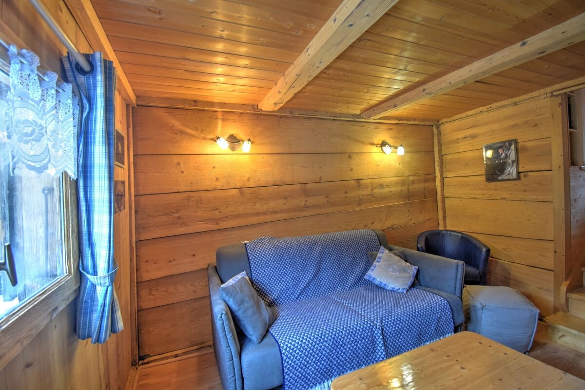 A wooden room with a couch and a chair