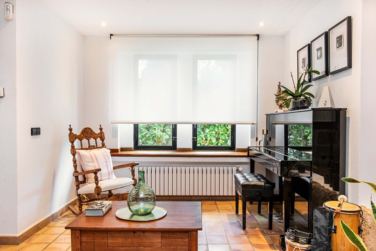 A living room with a rocking chair and a piano