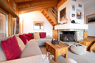 A living room with a fireplace and a couch with red pillows
