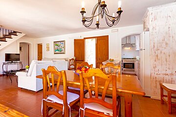 A dining room table with a bowl of fruit on it