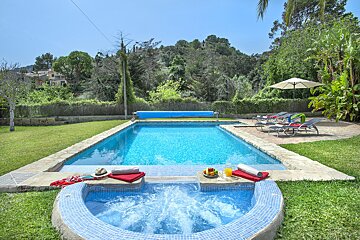 A large swimming pool with a jacuzzi in front of it