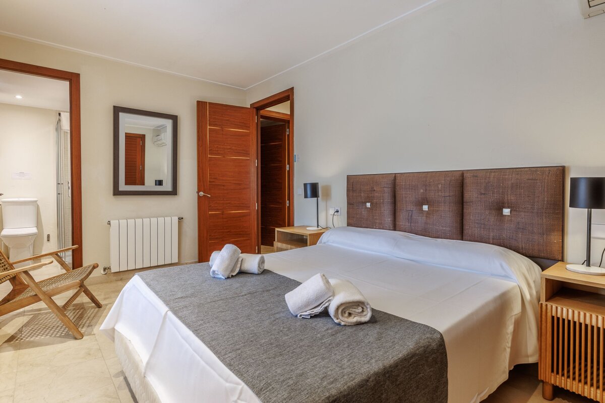 A bedroom with a large bed and a mirror