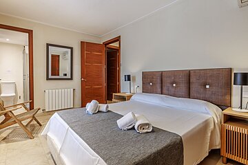 A bedroom with a large bed and a mirror