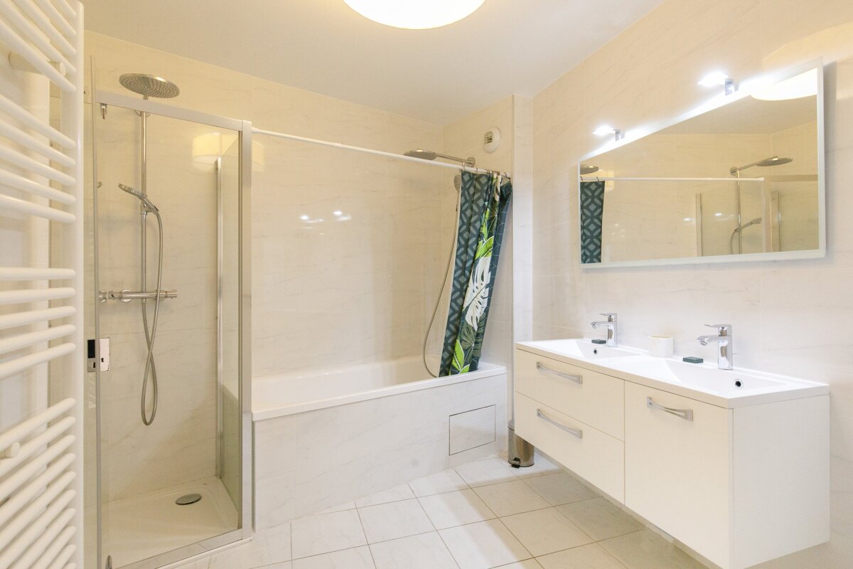 A bathroom with a bathtub and two sinks