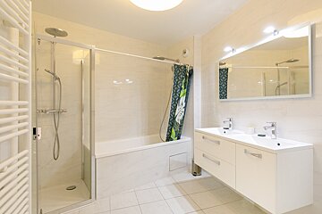 A bathroom with a bathtub and two sinks