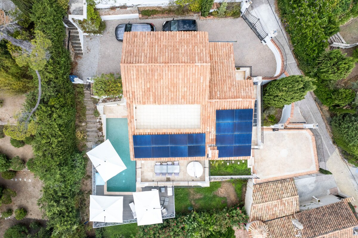 An aerial view of a house with solar panels on the roof